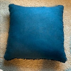 Navy blue pillow with fringe.